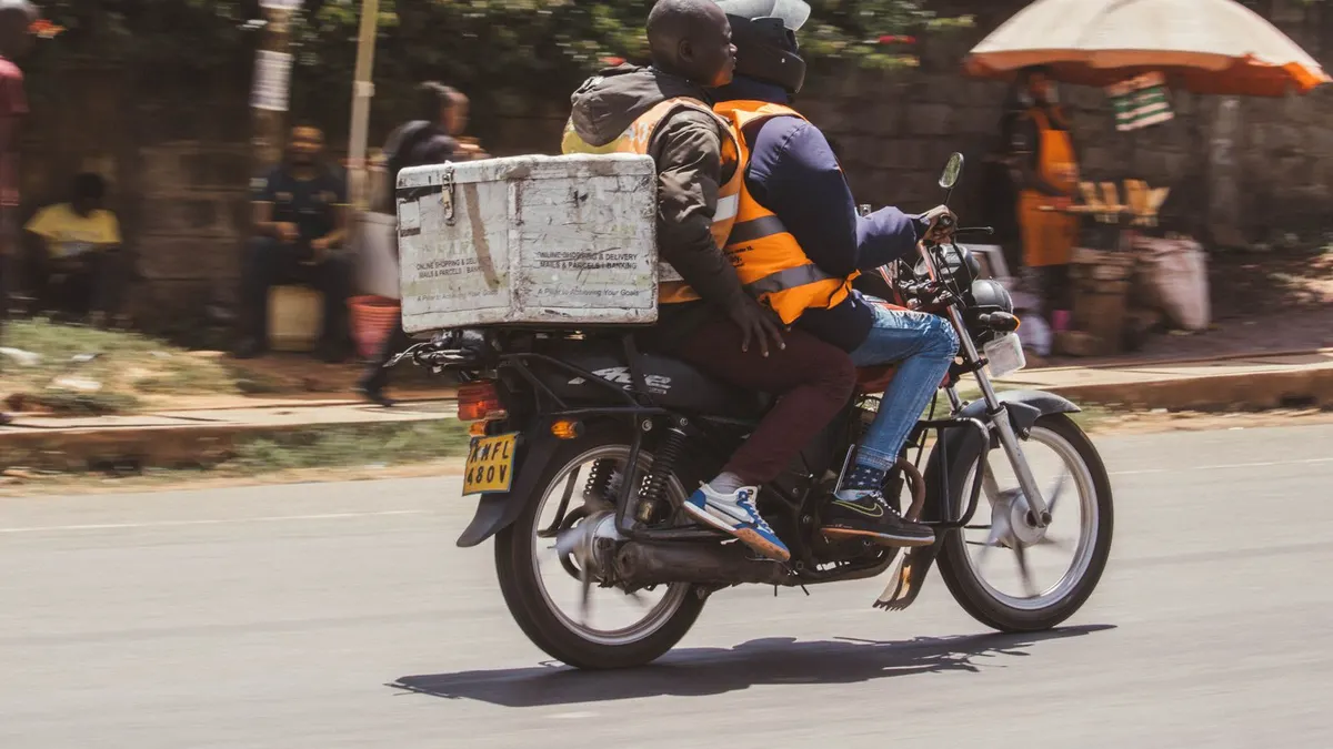 Motorcycle delivery rider with a parcel box in Nairobi, Kenya